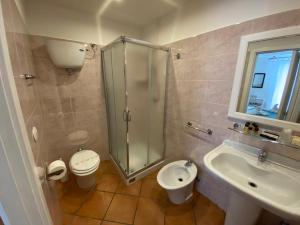 uma casa de banho com um chuveiro, um WC e um lavatório. em Tropea Boutique Hotel em Tropea