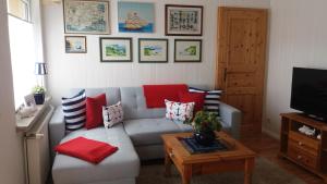 a living room with a gray couch with red pillows at Ferienwohnung Insel Rügen in Bergen auf Rügen