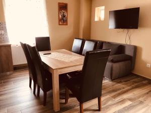 comedor con mesa y sofá en Adrienn Apartman, en Sárvár