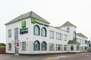 a white building on a street with a stop sign at Holiday Inn Express London Chingford by IHG in London