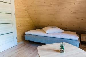 a room with a bed in a wooden room with a table at Domki Pod Czarnym Groniem in Rzyki +32 photos