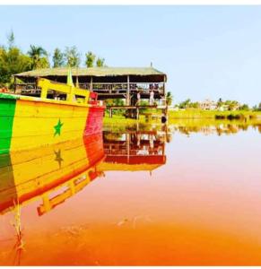a colorful boat is sitting in the water at Hotel le Trarza in Niaga