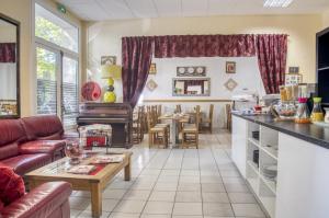 sala de estar con sofá y mesa en Citotel Hôtel Cesar, en Nimes