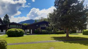 une maison avec un arbre dans la cour avant dans l'établissement Wildente am See, à Maishofen