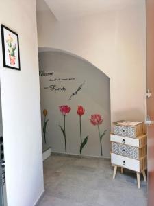 una habitación con una pared con flores pintadas en ella en FIORDAELISA APARTMENT, en Monforte dʼAlba