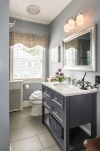 ein Badezimmer mit einem Waschbecken, einem WC und einem Spiegel in der Unterkunft The Chadwick Bed and Breakfast in Portland