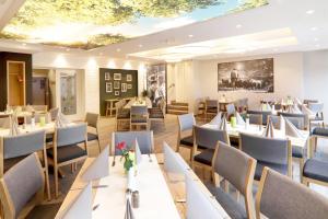 a restaurant with tables and chairs and a ceiling at Hotel & Restaurant Waldblick in Pulsnitz