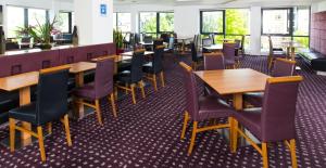 uma fila de mesas e cadeiras num restaurante em Holiday Inn Express Hemel Hempstead, an IHG Hotel em Hemel Hempstead