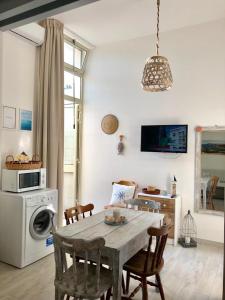 eine Küche mit einem Tisch, Stühlen und einer Mikrowelle in der Unterkunft Camere a Oriente in Torre dell'Orso
