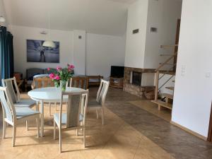 a living room with a table and chairs and a fireplace at Leśny domek in Chmielno