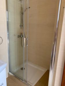 a shower with a glass door in a bathroom at Leśny domek in Chmielno +7 photos