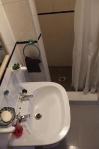 a white sink in a bathroom with a shower at Casa Avô T1 in Avô +23 photos