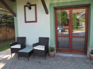2 sillas y una mesa en un patio junto a una puerta en A+S Penzion Podzamok, en Spišské Podhradie