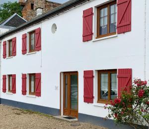 une maison blanche avec des fenêtres à volets rouges dans l'établissement La Maison Cent 5 avec parking privé, à Saint-Valery-sur-Somme