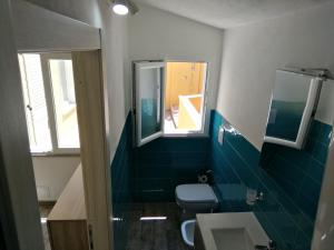 a bathroom with a toilet and a sink and two windows at Palau centralissimo in Palau +20 photos