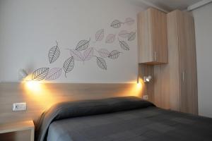 a bedroom with a bed and a wall with leaves at Apartments Palma & Pino in Cres