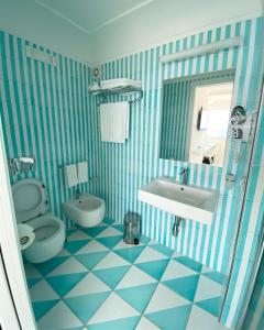 a blue and white bathroom with a toilet and sink at La Caravella di Positano - Relais & Beach in Positano