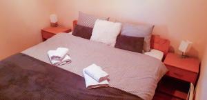 Un dormitorio con una cama grande con toallas. en Apartman šumski vilenjak, en Zlatibor
