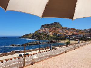- Vistas a la playa y a la ciudad con sombrilla en Hotel Meli, en Castelsardo
