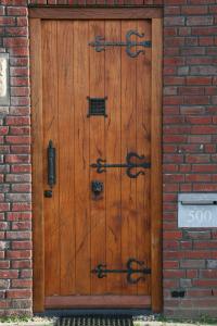 una puerta de madera en un edificio de ladrillo con graffiti en B&B Het kasteel, en Almere