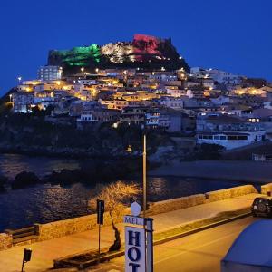 uma vista para uma cidade com uma montanha à noite em Hotel Meli em Castelsardo