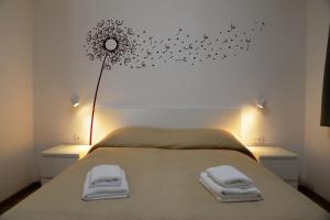 Schlafzimmer mit einem Bett mit Löwenzahn an der Wand in der Unterkunft Apartments Palma & Pino in Cres