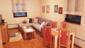 una sala de estar con un sofá y una mesa en Apartman šumski vilenjak, en Zlatibor