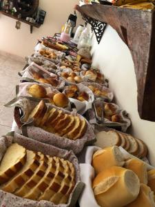uma fileira de pães e doces sobre uma mesa em Pousada Vale dos Sonhos em Cunha