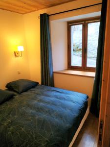 ein Schlafzimmer mit einem Bett und einem Fenster in der Unterkunft Appartement dans ferme rénovée au cœur du Grand Massif in Sixt