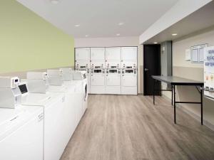 a laundry room with white cabinets and a table at WoodSpring Suites Merrillville in Merrillville