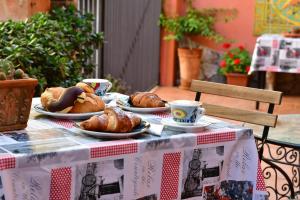 Casa Cifali في تاورمينا: طاولة مع أطباق من الكرواسون وأكواب القهوة