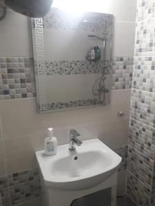 a bathroom with a sink and a mirror at Апартамент Оскар in Burgas City