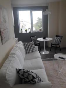 a living room with a white couch and a table at Апартамент Оскар in Burgas City