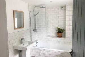 a white bathroom with a sink and a shower at North Wales Cottage Views, Walks, Dogs Welcome in Cilcain