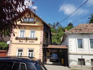 un coche aparcado frente a un edificio amarillo en Casa cu Cerdac, en Sighişoara