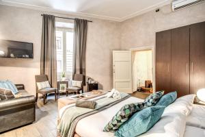 ローマにあるLa Residenza Dell'Angeloのベッド2台とソファが備わるホテルルームです。