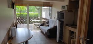 帕蘭加的住宿－Livingpalanga kotedzas，带沙发和桌子的厨房以及阳台。