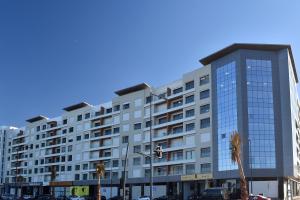 ein großes weißes Gebäude mit Palmen davor in der Unterkunft Le Yacht Suites Hotel in Casablanca