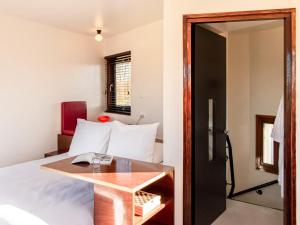 1 dormitorio con cama, mesa y puerta en SWEETS - IJdoornlaanbrug en Ámsterdam