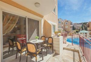 a patio with a table and chairs on a balcony at Pafilia Garden Apartments in Paphos