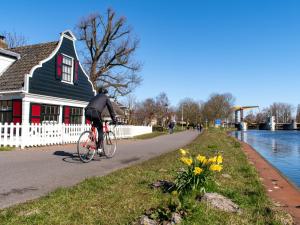 uma pessoa a andar de bicicleta num caminho ao lado de uma casa em SWEETS - IJdoornlaanbrug em Amsterdã
