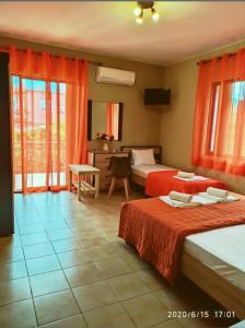 a hotel room with two beds with red curtains at Villa Anastasia in Limenas