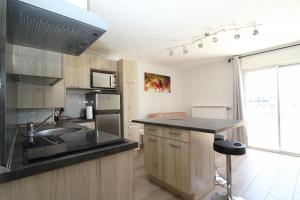 a kitchen with a sink and a counter top at Soleil Bleu - T2 classé 3 étoiles en front de mer in Canet-en-Roussillon