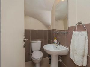 a small bathroom with a toilet and a sink at Pafilia Garden Apartments in Paphos