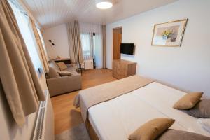 a bedroom with a bed and a living room at Penzion Livada in Kranjska Gora