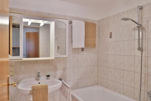 biała łazienka z umywalką i prysznicem w obiekcie Ferienwohnung Salzburg w mieście Bruck an der Großglocknerstraße +25 zdjęć