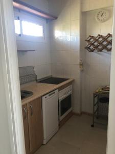 una pequeña cocina con fogones y lavavajillas en Sol y Paz, en Torremolinos