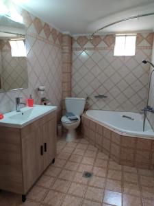 a bathroom with two sinks and a tub and a toilet at Ablaze Apartment in Limenaria