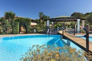 a swimming pool with a playground and a wooden bridge at Relais Fenicottero Rosa in Porto San Paolo