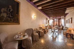 restauracja ze stołami i krzesłami oraz obrazem na ścianie w obiekcie Locanda Casa Martini w Wenecji